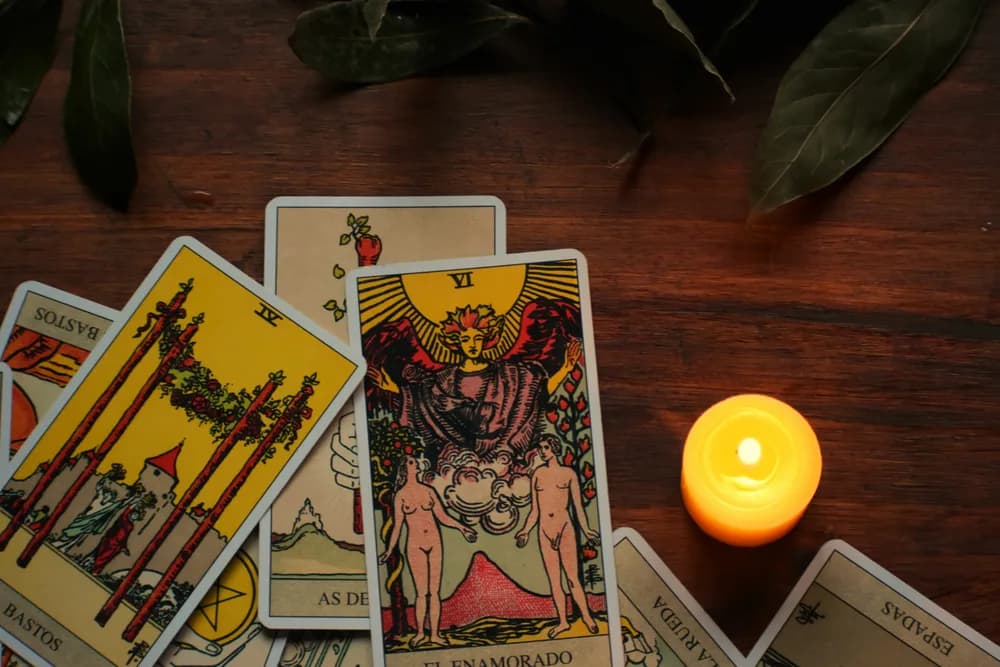 Consulta de tarot online com cartas e vela sobre a mesa