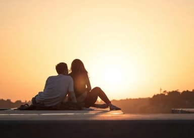 Casal feliz ao pôr do sol, compatibilidade entre signos do zodíaco